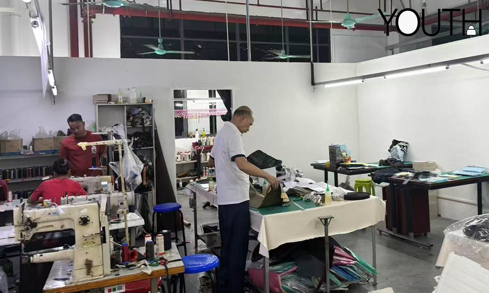 A photo showing the bags sampling room with designers cutting the materials
