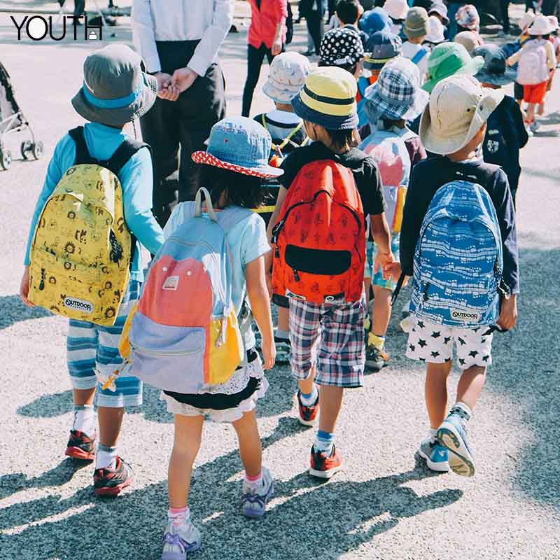 A group of children wearing different kind of backpacks after school