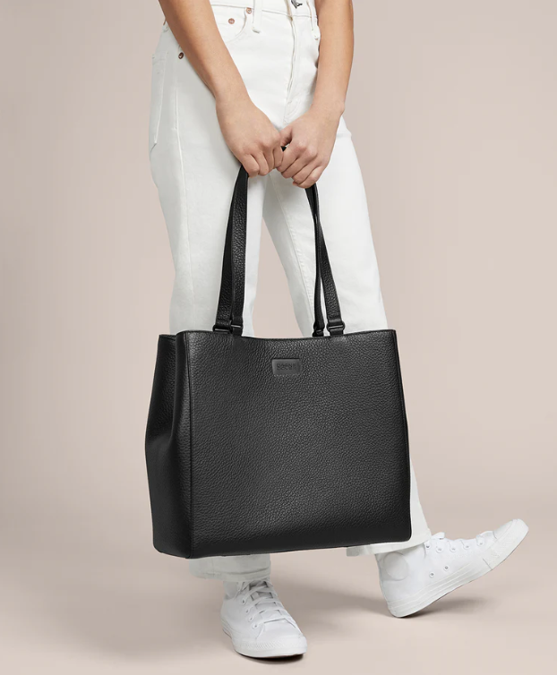 A lady taking a black dagne dover allyn tote bag in his hand