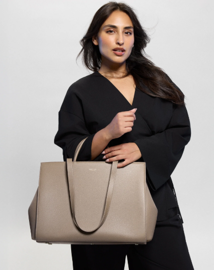A lady model in black coat holding a grey mina baie juliet work tote 2