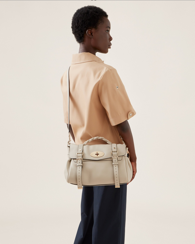 A black lady wearing a beige mulberry alexa crossbody bag for showing